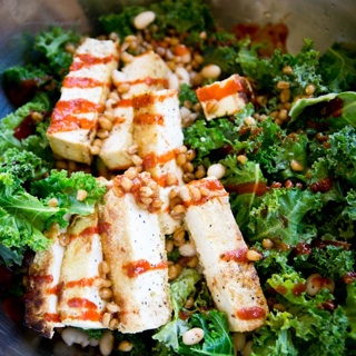 kale salad with wheat berries, navy beans, grilled tofu, soy sauce dressing and sriracha